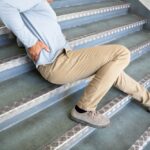 Mature Man Lying On Staircase After Slip And Fall Accident