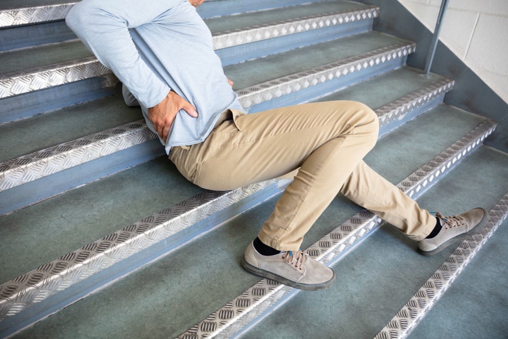 Mature Man Lying On Staircase After Slip And Fall Accident